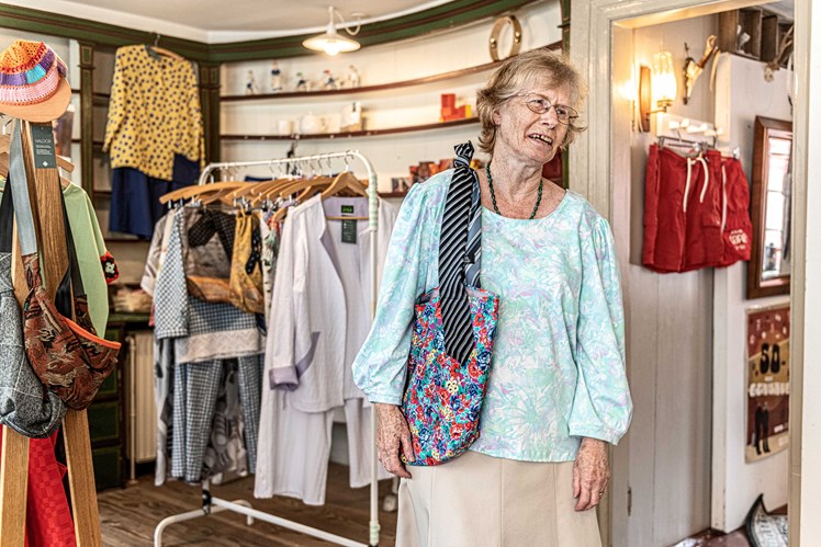 Mö & Flös er primært drevet af kreative unge frivillige – og ifølge Mette Prahl kommer der så mange, der gerne vil være frivillige i butikken, at personalet ofte er nødt til at sige nej. 70-årige Ina har været frivillig i fem år og viser her en taske, som hun har lavet af et gammelt slips og en stofrest: – Jeg synes selv, det er sjovt at sy, og det vil jeg gerne give videre til de unge, siger hun.