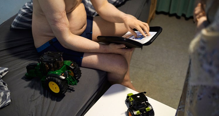 06:02 - Billedernes sprog: De fleste af Lyngdals beboere er ligesom Victor nonverbale. Kommunikationen foregår i stedet via piktogrammer, der illustrerer situationen, de er i – eller står over for. En måne for nat. En bruser for bad. Eller som her et hæfte med de specifikke film, Victor kan vælge at se. Piktogrammerne hjælper personalet til at skrue mest muligt ned for sproget, så borgerne ikke overstimuleres.