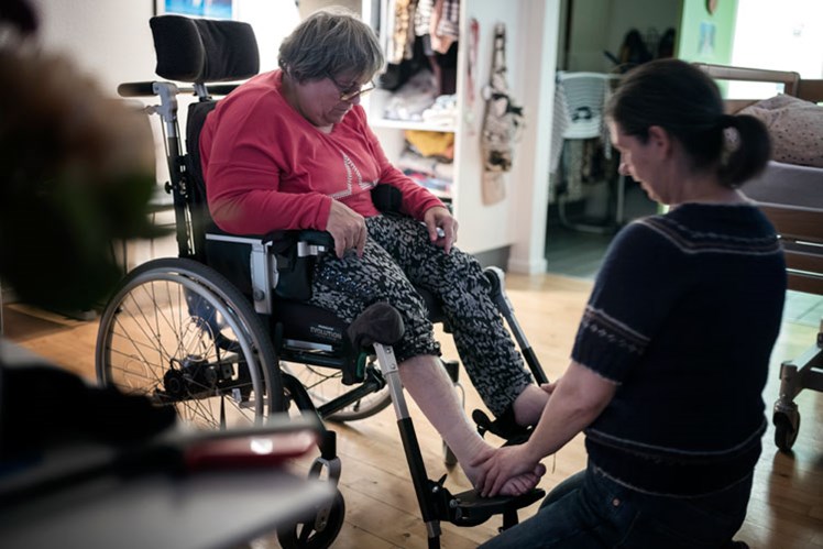 – Vi starter med et fodbad, og så kommer jeg og smører dine fødder ind i creme, siger socialpædagog Susan Buchard til en beboer, som skal have fodmassage. Hun har som alle andre et behov for at blive rørt ved – og på Kamager er berøring meget mere end personlig pleje. Det er følelsen af at mærke sin krop og mærke, at man er til.