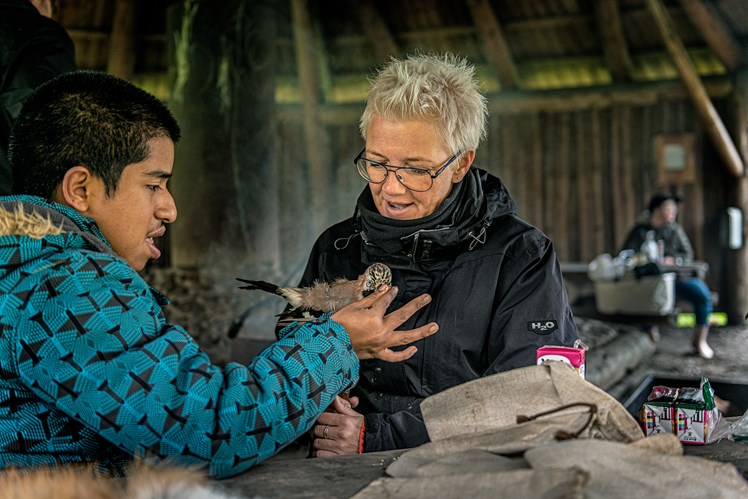 – Det er meget inspirerende at være sammen med naturvejledere, for de viser, hvordan man også kan bruge naturen til at styrke trivsel og relationer blandt de unge, fortæller socialpædagog Lisbeth Ebsen. Hun har en rolig stund sammen med Jefferson, som genkender en af de udstoppede fugle, naturvejlederne har taget med – og den vil han gerne fodre.
