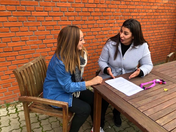 Michell sidder med kollegaen Naden Abou-harb og gennemgår lønsedlen. Naden er nyuddannet og i tvivl om hvordan man læser sin lønseddel. De taler også om Socialpædagogerne som fagforening og om det er den rigtige fagforening for Naden.