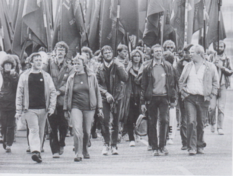 1984: Forbundsformand Jens Asger  Hansen (tv.) og andre fagpolitiske socialpædagoger til protestdemonstration mod Folketingets åbning i oktober 1984. Forbundets kamp mod den borgerlige Schlüter­regering var intens i begyndelsen af 80’erne, da dens politik både førte til nedgang i medlemmernes realløn og nedskæringer i den offentlige sektor. - Arkivfoto fra Socialpædagogernes Historie
