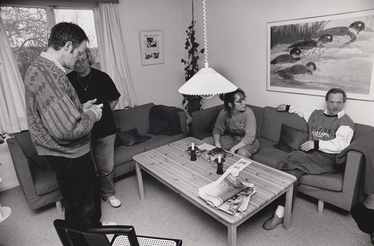 1991: Samvær i dagligstuen i et nyt bofællesskab for voksne udviklingshæmmede i Farum. Dagligdagen i de mange nye bofællesskaber, der skyder op i takt med afviklingen af centralinstitutionerne, giver socialpædagoger en ny rolle som gæster i borgernes hjem. Hvor meget bør og kan de bestemme? Og hvor trækker man grænsen over for pårørende til unge udviklingshæmmede, der flytter direkte ud i de nye boformer? De mange etiske spørgsmål tager forbundet op på konferencen ’Etikkens Ansigter’ i begyndelsen af 90’erne. - Arkivfoto Kurt Johansen